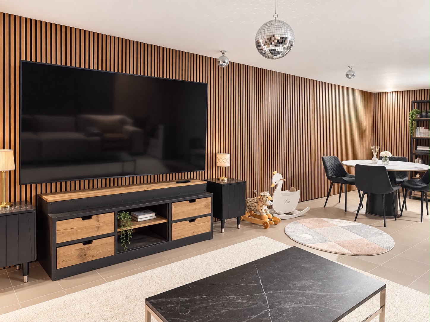 Nedre lounge med stor TV, sittgrupp, leksaker och separat matplats
